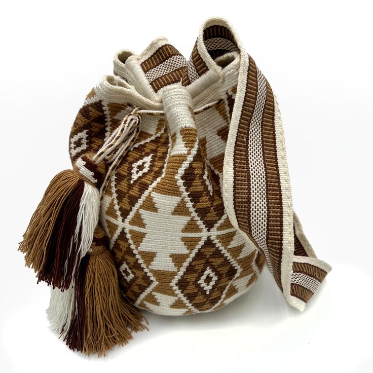 a brown and white bag with tassels on the bottom is sitting in front of a white background