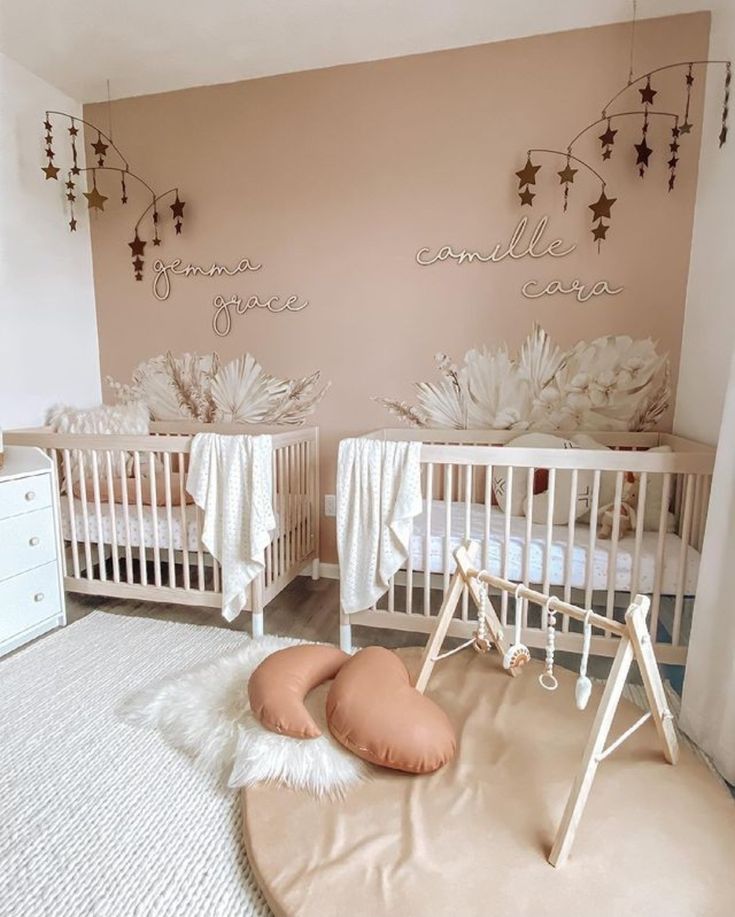 two baby cribs in a pink and white nursery