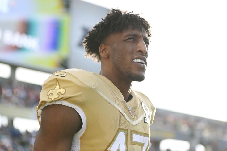 a close up of a football player wearing a uniform and looking off into the distance