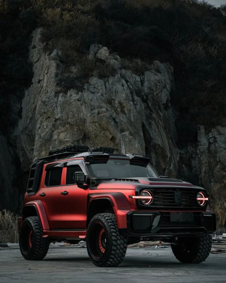 a red truck parked in front of a mountain