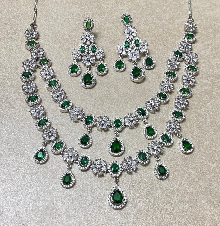 Emerald diamond necklace featuring semi precious green stone and cz diamonds. Ideal to pair with your indo western sarees and lehngas. This SABYASACHI INSPIRED necklace surely elevate your look and add a touch of beauty. Perfect gift for her. 𝐏𝐑𝐎𝐃𝐔𝐂𝐓 𝐃𝐄𝐓𝐀𝐈𝐋* * 𝐌𝐚𝐭𝐞𝐫𝐢𝐚𝐥: Brass * 𝐏𝐥𝐚𝐭𝐢𝐧𝐠: White Rhodium Plated * 𝐒𝐭𝐨𝐧𝐞: AAA-quality CZ Diamond & Emerald. *𝐃𝐈𝐌𝐄𝐍𝐒𝐈𝐎𝐍𝐒* *𝐍𝐞𝐜𝐤𝐥𝐚𝐜𝐞* * 𝐖𝐞𝐢𝐠𝐡𝐭: 63 gm  * 𝐃𝐫𝐨𝐩  𝐋𝐞𝐧𝐠𝐭𝐡: 7 Inches * 𝐖𝐢𝐝𝐭𝐡: 2 Emerald Green Indian Jewelry, Dazzling Green Emerald Necklace, Elegant Emerald Jewelry With Stone Work, Green Emerald Bridal Necklace For Wedding, Silver Kundan Necklace With Hand-set Emeralds, Elegant Green Jewelry With Stone Work, Green Emerald Jewelry Sets For Wedding, Elegant Green Emerald Necklace With Stone Work, Green Emerald Necklaces For Weddings