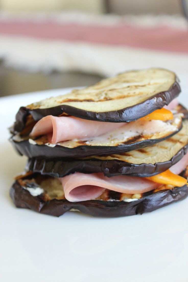 an eggplant, ham and cheese sandwich is stacked on top of each other