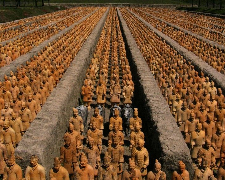 rows of terracotts are arranged in the shape of men with faces on them