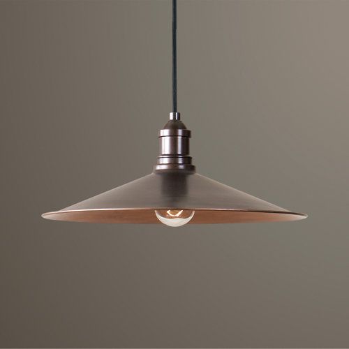 a light hanging from a ceiling with a gray wall behind it and a black cord