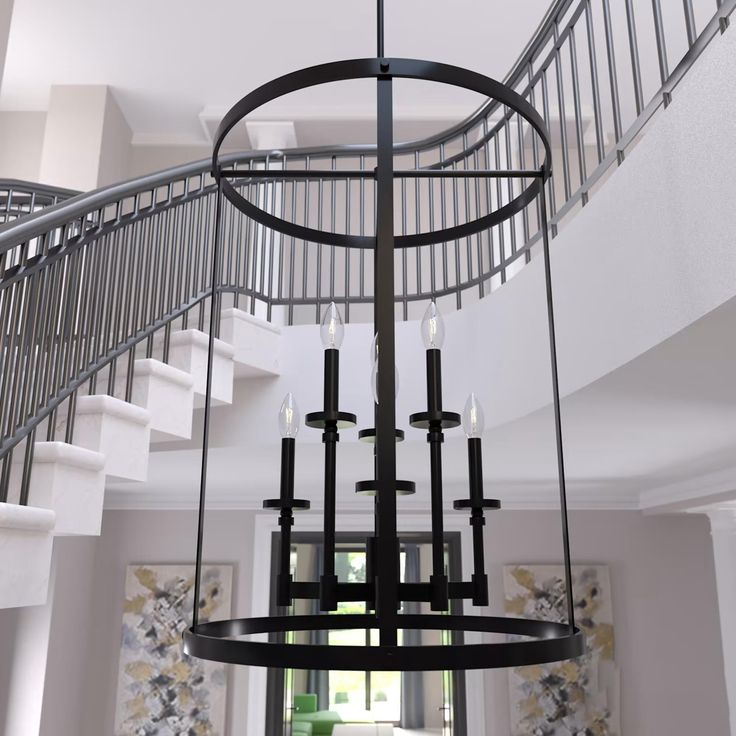 a large chandelier hanging from the ceiling in a living room next to stairs