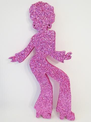 a pink glitter figure sitting on top of a white surface