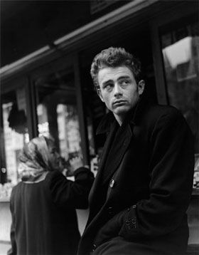 a black and white photo of a man sitting on a bench