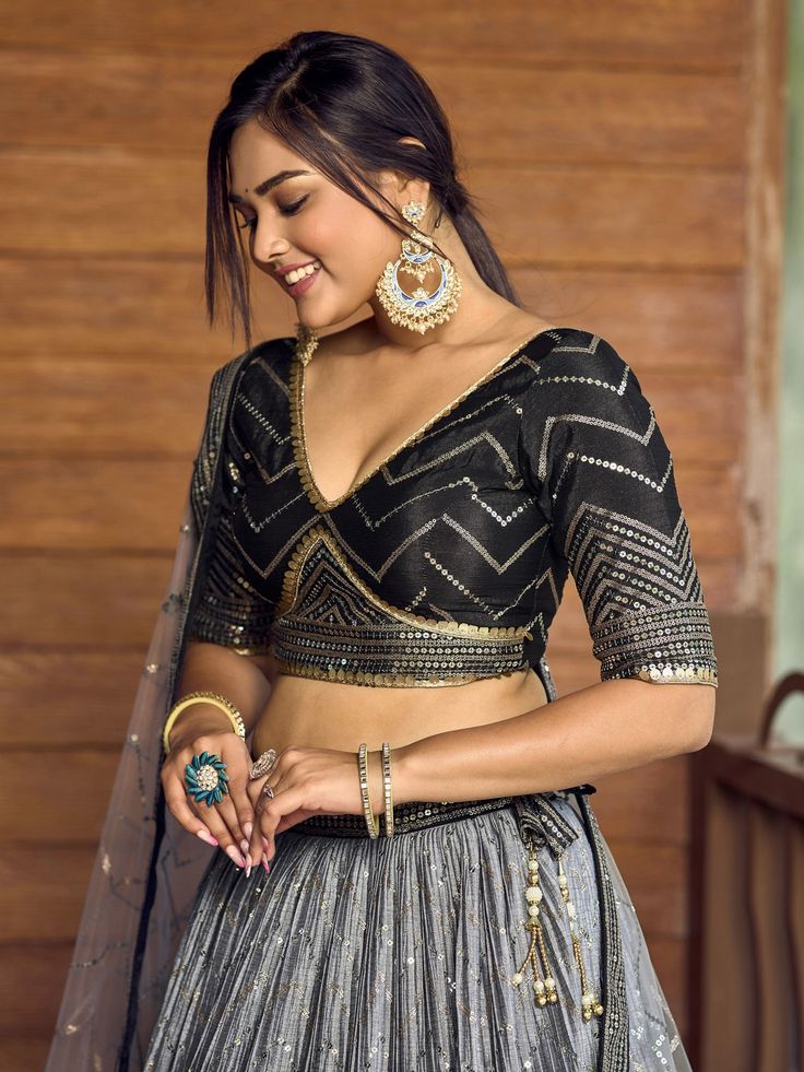 Add elegance and sophistication to your ethnic wardrobe with our fabulous black sequins chinon reception wears lehenga choli. This stunning ensemble includes a black color chinon material lehenga with intricate thread embroidered work and sequin detailing, complemented by a similar color chinon choli featuring matching embroidery and sequin work. The look is completed with a light grey net dupatta adorned with sequin work and a captivating lace border.
This outfit includes its semi-stitched blac Semi-stitched Embellished Black Anarkali Set, Embellished Black Pre-draped Saree For Party, Designer Black Blouse Piece For Navratri, Designer Black Blouse For Navratri, Festive Black Pre-draped Saree With Sequins, Black Pre-draped Saree For Navratri, Black Embellished Sharara For Diwali, Bollywood Style Embellished Black Sharara, Black Embellished Dupatta With Traditional Drape