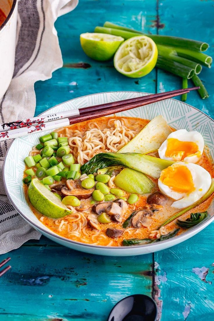 a bowl of ramen with noodles, vegetables and hard boiled eggs