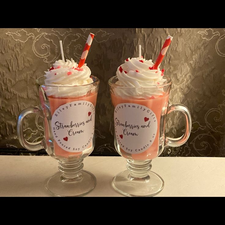 two mugs with whipped cream and strawberries on top, one is filled with milkshakes