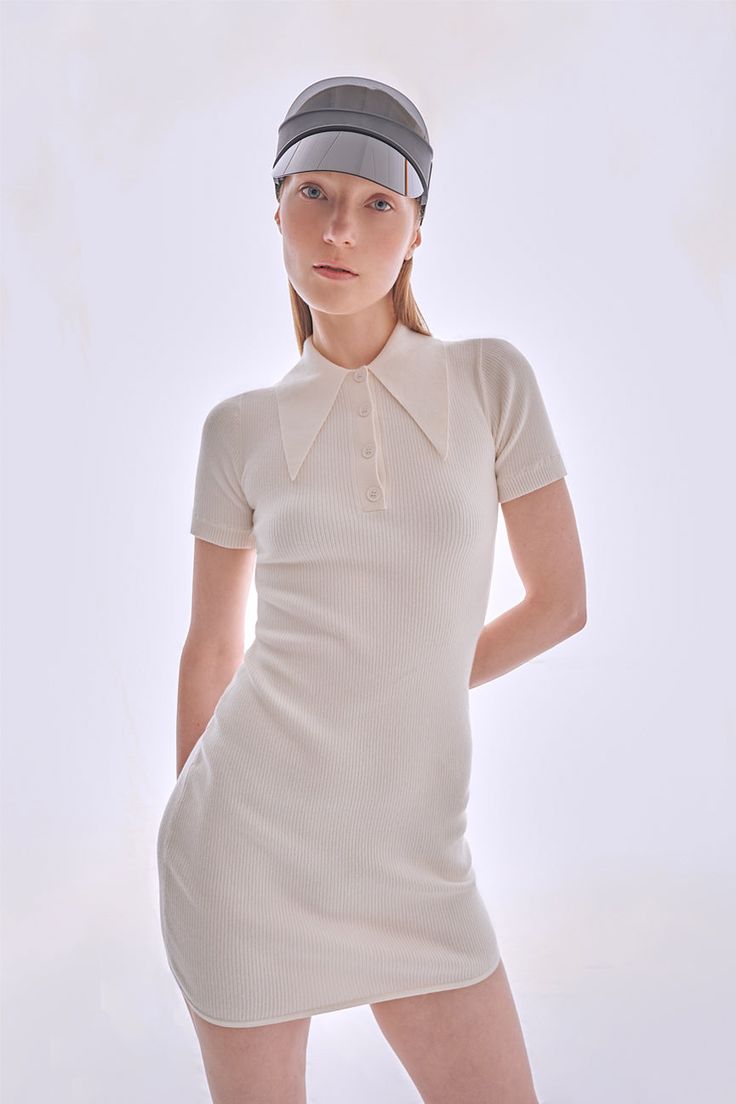 JUST ONE LEFT - FINAL SALE! Our signature rib mini polo dress is back in stock. She is beautifully fitted and flattering for a sophisticated, retro-active silhouette. Knit in peachskin, with a 70s style collar and buttons down the front. Also available in Hello Sailor. Our signature peachskin classics are instant wardrobe staples. They stand out for their softness, simplicity, and comfort. Not only are they stretchy and perfectly form-fitting, but they also have slight compression properties tha Classic Fitted Polo Dress, Fitted Collared Polo Dress Classic Style, Fitted Classic Collared Polo Dress, Classic Fitted Collared Polo Dress, Fitted Polo Dress For Work With Collared Neckline, Fitted Short Sleeve Polo Dress For Work, Classic White Fitted Mini Dress, Fitted Polo Dress With Short Sleeves For Work, Elegant Fitted Polo Dress With Collared Neckline