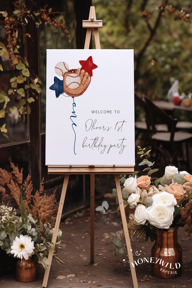 a welcome sign is on an easel with flowers