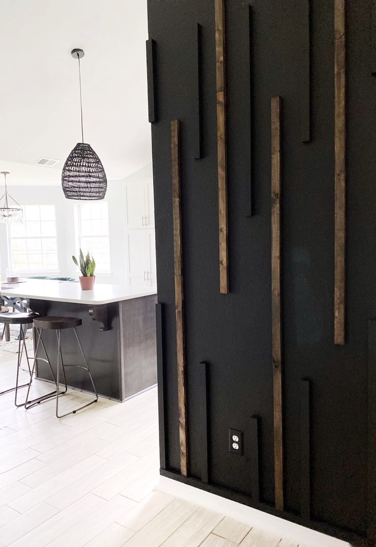 a kitchen with black walls and white flooring next to a counter top island in the middle