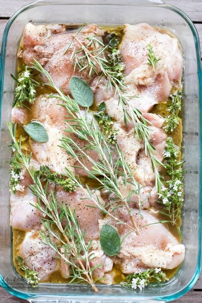 a casserole dish with chicken, herbs and seasoning in it on a wooden table