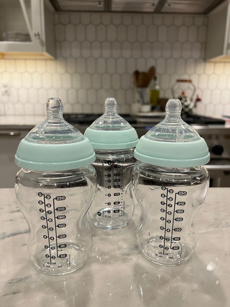 two baby bottles sitting on top of a counter