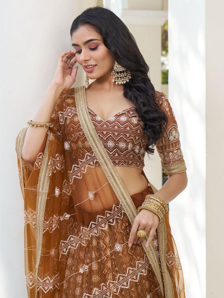 Indulge in the timeless elegance of this enchanting brown butterfly net lehenga adorned with intricate details of cotton threadwork, sequins, and embroidered motifs. The rich, earthy hue adds a touch of sophistication to your ensemble, while the delicate craftsmanship enhances its allure.
The semi-stitched lehenga boasts a generous 3-meter flair, ensuring graceful movement with every step, and can be customized up to 42 inches to perfectly complement your silhouette. Paired with an unstitched ch Brown Resham Embroidered Sets For Diwali, Brown Sets With Resham Embroidery For Diwali, Brown Resham Embroidery Sets For Diwali, Festive Brown Party Sets, Elegant Brown Festive Sets, Brown Dupatta With Resham Embroidery For Navratri, Festive Brown Lehenga With Traditional Drape, Brown Lehenga With Dupatta For Wedding, Festive Brown Lehenga With Dupatta