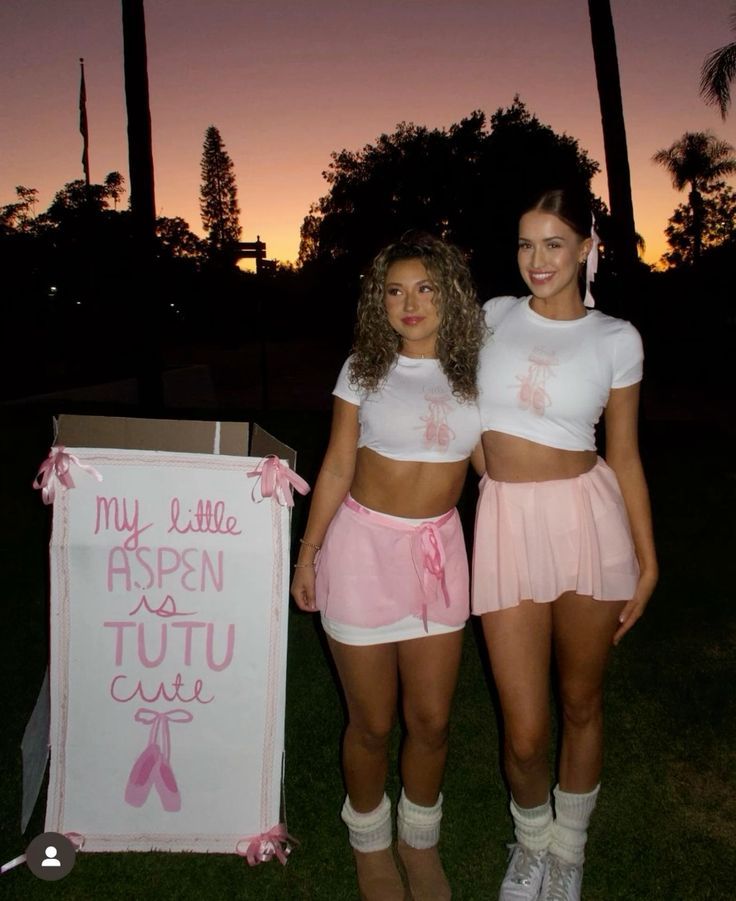 two young women standing next to each other in front of a sign