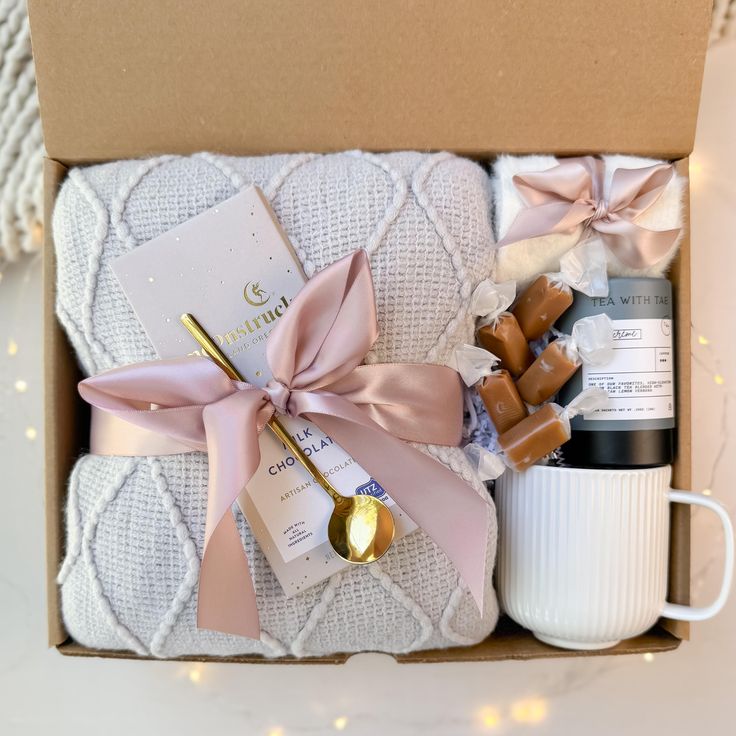 an open box with some items in it sitting on a table next to a cup