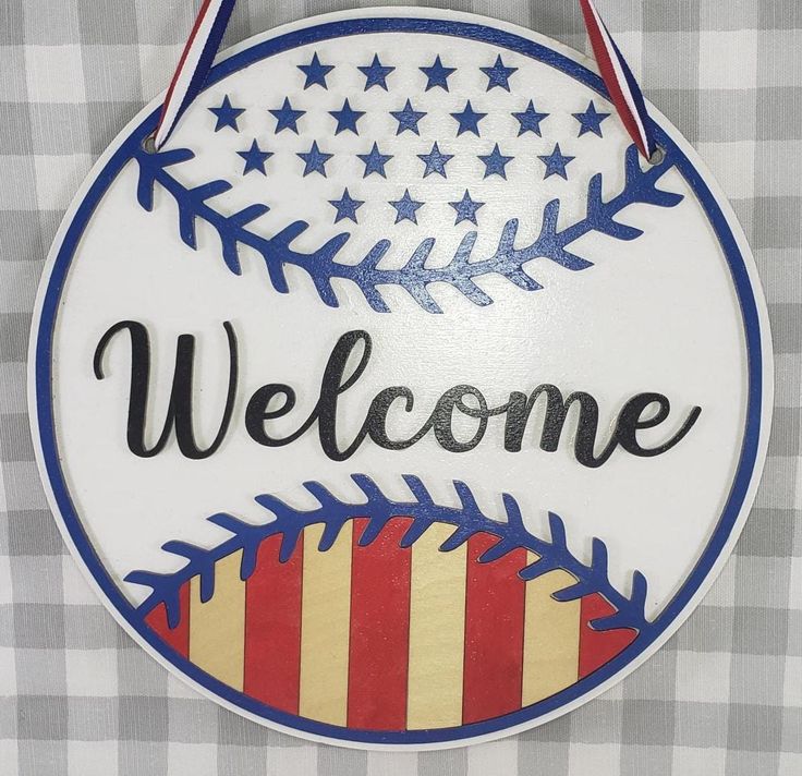 a welcome sign hanging from the side of a wall next to a checkered table cloth