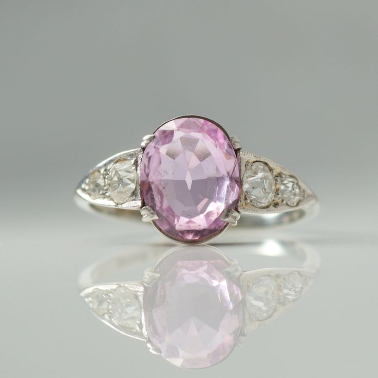 Fabulous Art Deco Pink Topaz Ring circa 1920 Featuring an Oval pink topaz which measures approx 1.75 carats, with three old cut diamonds to the shoulders, measuring approx .20 carats each side,  H colour and VS clarity. The topaz is set with four double claws on a raised pierced out mount, leading to a plain band shank and measures 9.5mm in width.  To the reverse the topaz and diamonds are set in an open backed setting which allows the light to shine through. This lovely ring would make the perf 1920s Ring, Memory Ring, Topas Ring, Topaz Diamond Ring, Topaz And Diamond Ring, Pink Topaz Ring, Art Deco Pink, Plain Bands, Pink Topaz