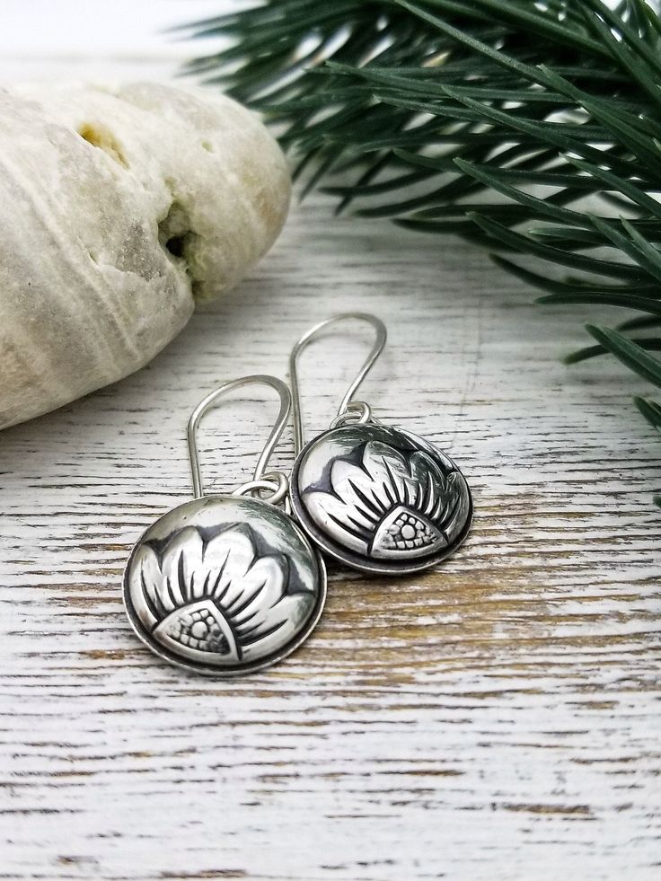 These sweet little silver flower earrings are sure to become your new grab-n-go pair! A little bit romantic, a little bit whimsical ... they are sure to brighten up any outfit you choose to wear them with. I impress this delicate floral pattern into sterling silver sheet metal to form a domed circle. Then I solder them to an open sterling silver backing to give them a little more substance yet still keeping them lightweight. I add a patina, hand polish them to a soft luster and suspend them on h Delicate Silver Earrings With Flower Charm, Delicate Silver Drop Flower Earrings, Delicate Silver Flower Earrings Nickel Free, Delicate Silver Flower Earrings Nickel-free, Delicate Silver Nickel-free Flower Earrings, Silver Delicate Nickel-free Flower Earrings, Silver Nickel-free Flower Earrings For Anniversary, Hypoallergenic Silver Flower Earrings For Gift, Delicate Sterling Silver Birth Flower Earrings