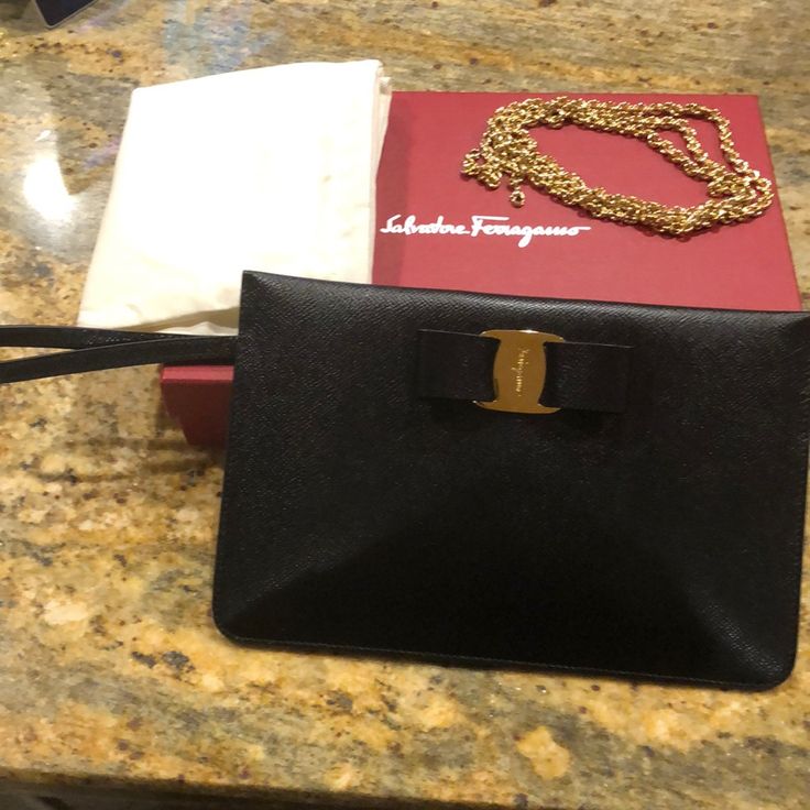 Beautiful Large Black Wristlet With Bow. Approximate 6 X9.5. Also Comes With A Chain To Be Worn Over The Shoulder. Elegant And Versatile! Designer Pouch With Original Box For Gift, Designer Pouch With Original Box As Gift, Rectangular Leather Wristlet For Evening, Designer Clutch Pouch With Gold-tone Hardware, Evening Clutch With Wrist Strap, Designer Clutch Wallet With Gold-tone Hardware, Leather Evening Wallet With Wrist Strap, Evening Leather Wallet With Wrist Strap, Black Clutch Wristlet For Gift