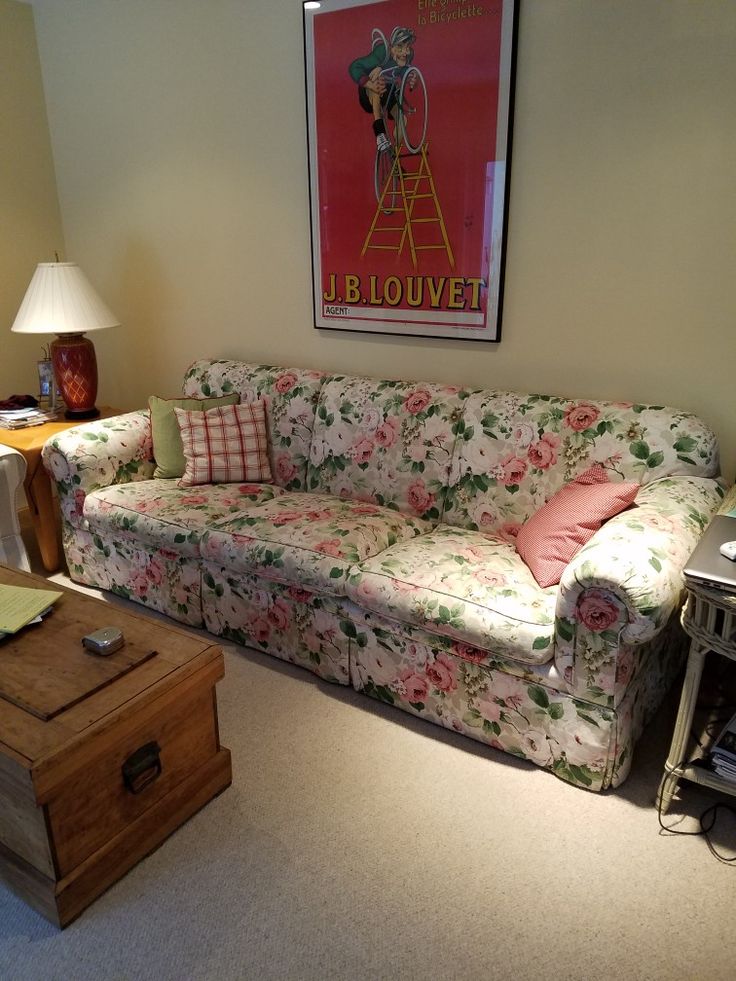 a living room filled with furniture and a painting on the wall above it's couch