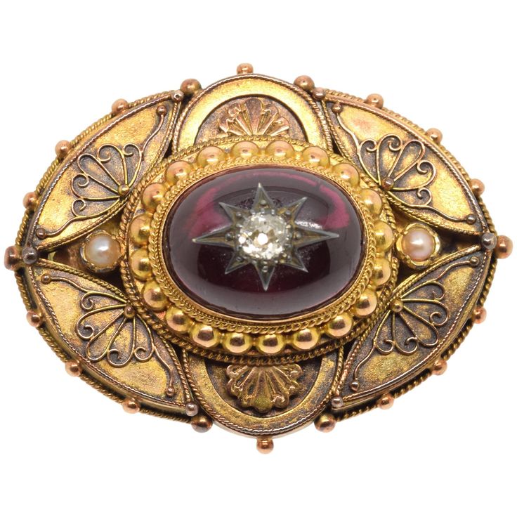 14-carat gold clasp with garnet and diamond. 14-carat gold-plated oval brooch finished with a gold-plated beaded cord adorned at the front with a curved composition that leaves smooth spaces for simplified plant motifs and two semicircles on the vertical axis of the smaller side which cover other plant elements. In the center, framed by a band with strings and pearls in gold and with two small pearls on the major axis (in the triangular spaces that leave the curves already mentioned), is placed Luxury Oval Jewelry For Opera, Victorian Oval Jewelry For Opera, Ceremonial Gold Brooches With 17 Jewels, Oval Yellow Gold Brooches With Gemstone, Antique Brooches For Formal Occasions, Elegant Cabochon Jewelry For Ceremonial Occasions, Ceremonial Gold Brooch Jewelry, Heirloom Oval Gemstone Brooches, Luxury Hallmarked Oval Brooch