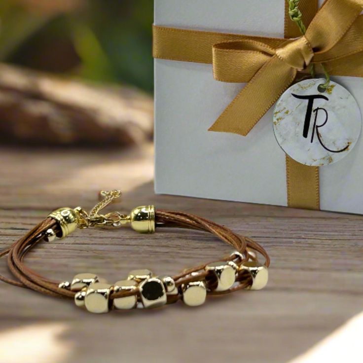 Get ready to elevate your wrist game with this multi-strand leather bracelet. Featuring gold-plated floating beads and a lobster clasp closure, this timeless piece is the perfect way to add a touch of sophistication to any outfit. Length: 6.5" + 1.5" extender chain - for an adjustable fit Lobster clasp closure - for a secure fit 6 strands of brown leather - for the perfect boho vibe 18K PVD Gold plated stainless steel - long lasting plating and hypoallergenic Handmade in China - to bring you the Adjustable Everyday Jewelry With Gold Clasp, Adjustable Gold Leather Bracelet Chic Style, Adjustable Gold Leather Chic Bracelet, Gold Adjustable Double Strand Beaded Bracelets, Gold Multi-strand Wrap Bracelet For Gift, Elegant Gold Metal Wrap Bracelet, Adjustable Gold Leather Bracelet, Gold Leather Bracelets As Gift, Gold Leather Bracelet As Gift