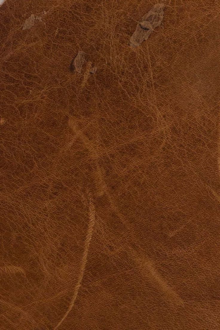 a close up view of a brown leather textured surface with some scratches on it