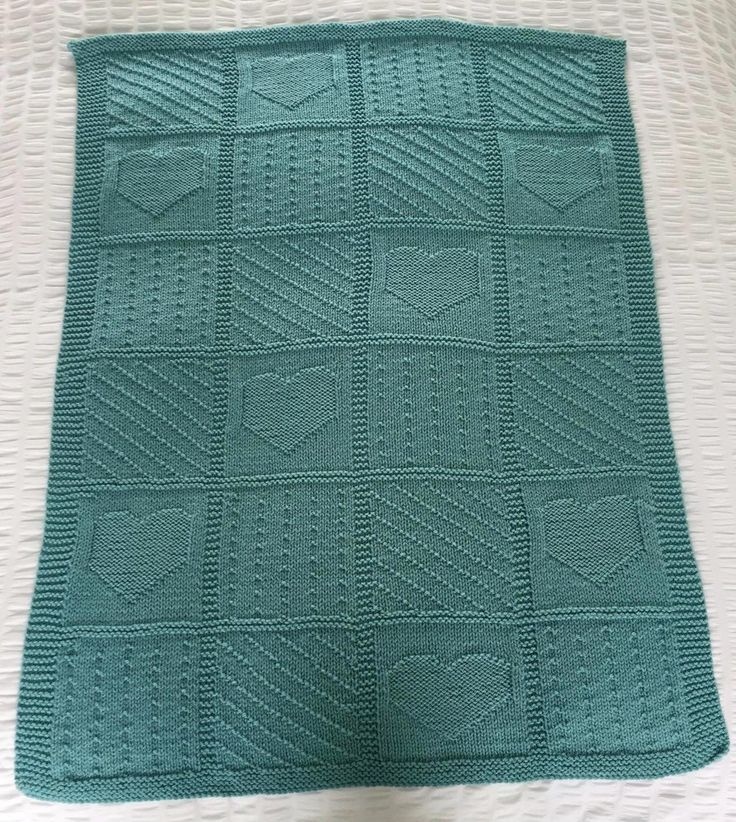 a green crocheted blanket sitting on top of a bed