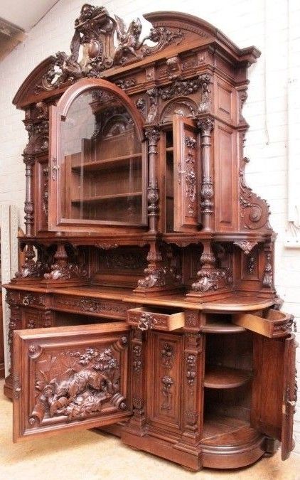 an old fashioned wooden cabinet with carvings on the doors and drawers, in a room