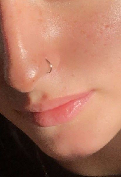 a close up of a woman's nose and nose with a piercing on it