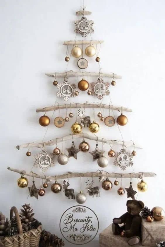 a small christmas tree with ornaments hanging from it's sides and on the wall