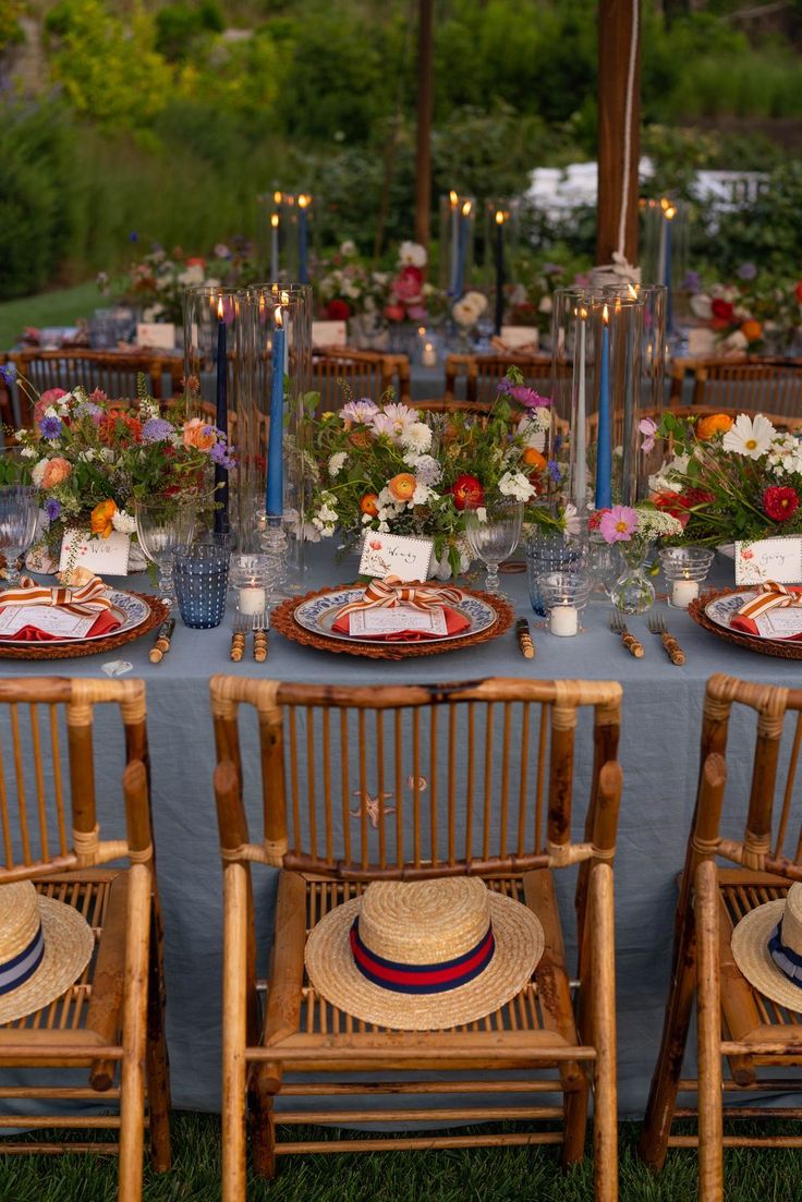 a table set up with plates and place settings for an outdoor dinner or party in the garden