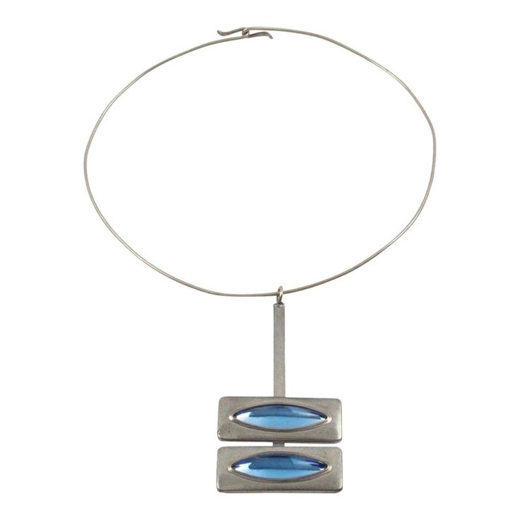 An elegant Space Age modernist collar pendant-necklace designed by Danish jewelry artist Jorgen Jensen. Made in pewter with arctic blue poured glass cabochons. Signed at the back: "Pewter - Jorgen Jensen - Denmark." Measurements: collar circumference is 16.13 in (41 cm) - pendant is 3.13 in high (7.9 cm) x 1.69 in wide (4.2 cm) - fit a Small to Medium size neck.  Please see the measurements noted above in the description for the best approximate dimensions.  About: Jorgen Jensen (b. 1931, no rel Modern Blue Metal Jewelry, Modern Blue Necklace, Modern Blue Metal Necklaces, Modern Blue Metal Necklace, Modern Blue Necklace With Polished Finish, Modern Blue Necklaces With Polished Finish, Modern Silver Glass Necklaces, Arctic Blue, Pewter Metal