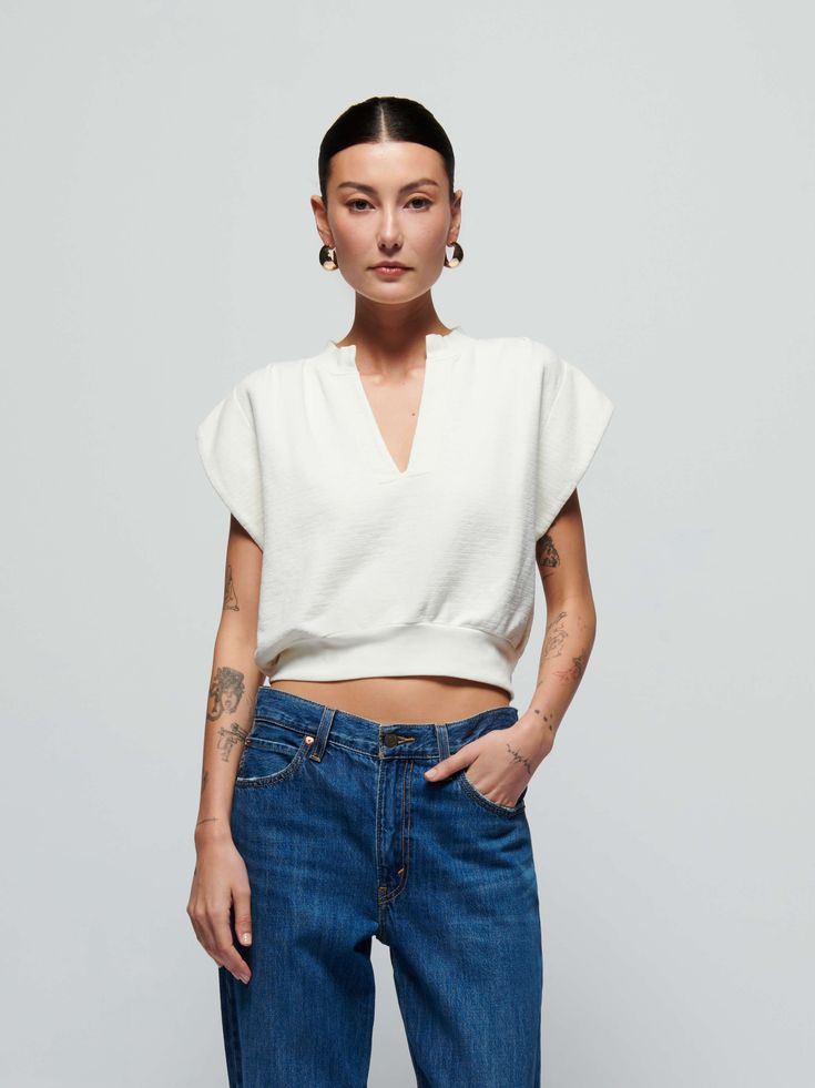 When casual meets chic, you get this sweatshirt top with a daring notch neckline, breezy cap sleeves, and a semi cropped silhouette. (This one comes in Porcelain.) Wear it with the Lincoln Pant. | Lenon Top in Porcelain | Ethical Essentials Relaxed Fit V-neck Crop Top, Chic Crew Neck Tops For Casual Gatherings, Chic Slightly Cropped Top For Fall, Chic Cropped Short Sleeve Top For Spring, Effortless White Top For Casual Gatherings, Chic White Tops For Casual Gatherings, Chic White Top For Casual Gatherings, Chic Cropped Relaxed Fit Tops, Chic Cropped Tops With Relaxed Fit