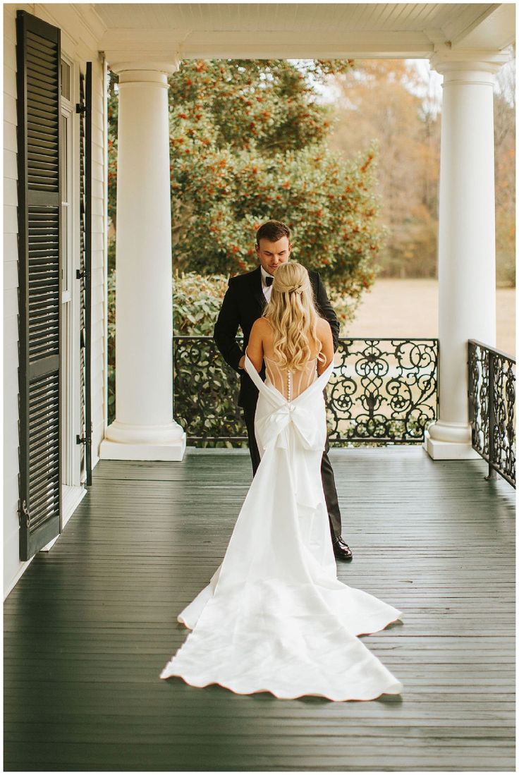 a bride and groom are standing on the porch