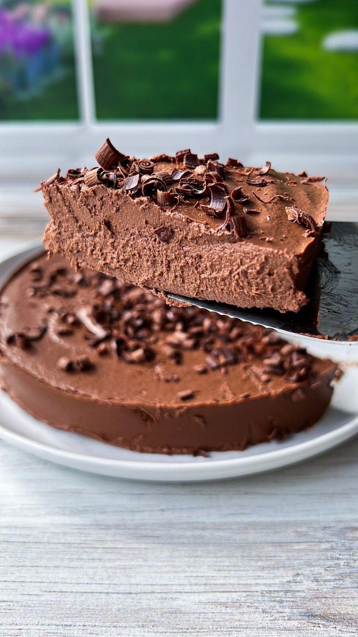 a piece of chocolate cake sitting on top of a white plate