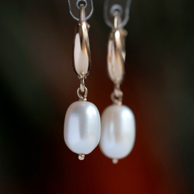 "Add a touch of elegance to any outfit with these beautiful 14k gold pearl earrings. White freshwater pearls are handpicked for their luster and beauty and dangle gracefully from 14k gold leverback closures. Luxurious and durable, these earrings are a great gift for any occasion, like a wedding, or for everyday wear.  MATERIALS * Freshwater Pearls * 14k Gold or 18k Gold * beautiful white branded gift box * card about white pearl SIZE: pearls: 10x7.5 mm;  earrings: 3 cm or 1 3/16\" MAKE A SET: Ma Elegant Hoop Clip-on Earrings For Formal Occasions, Elegant Hoop Clip-on Earrings For Formal Events, Elegant White Huggie Jewelry, Elegant Formal Clip-on Hoop Earrings, Elegant Huggie Pearl Earrings, Elegant Pearl Hoop Earrings With Ear Wire, Elegant Formal Huggie Earrings With Lever Back, Elegant Everyday Earrings With Lever Back, Classic Rose Gold Teardrop Hoop Earrings