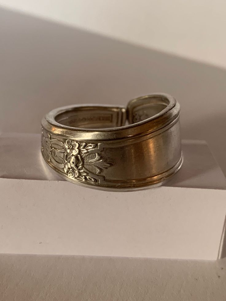 "Handcrafted from a vintage 1847 Rogers Bros silver plated spoon, this ring earns the \"Ambassador\" label through its intricate interwoven symbols representing many nations. Pictured here is a size 11. For other sizings, please ask! We'll try to find you a fit." Antique Silver Engraved Vintage Rings, Vintage Engraved Wide Band Jewelry, Vintage Sterling Silver Engraved Stamped Ring, Vintage Sterling Silver Engraved Ring With Stamped Details, Vintage Wide Band Jewelry Stamped 925, Vintage Sterling Silver Wide Band Jewelry, Vintage Wide Band Engraved Jewelry, Vintage Engraved Antique Silver Rings, Vintage Engraved Silver Ring