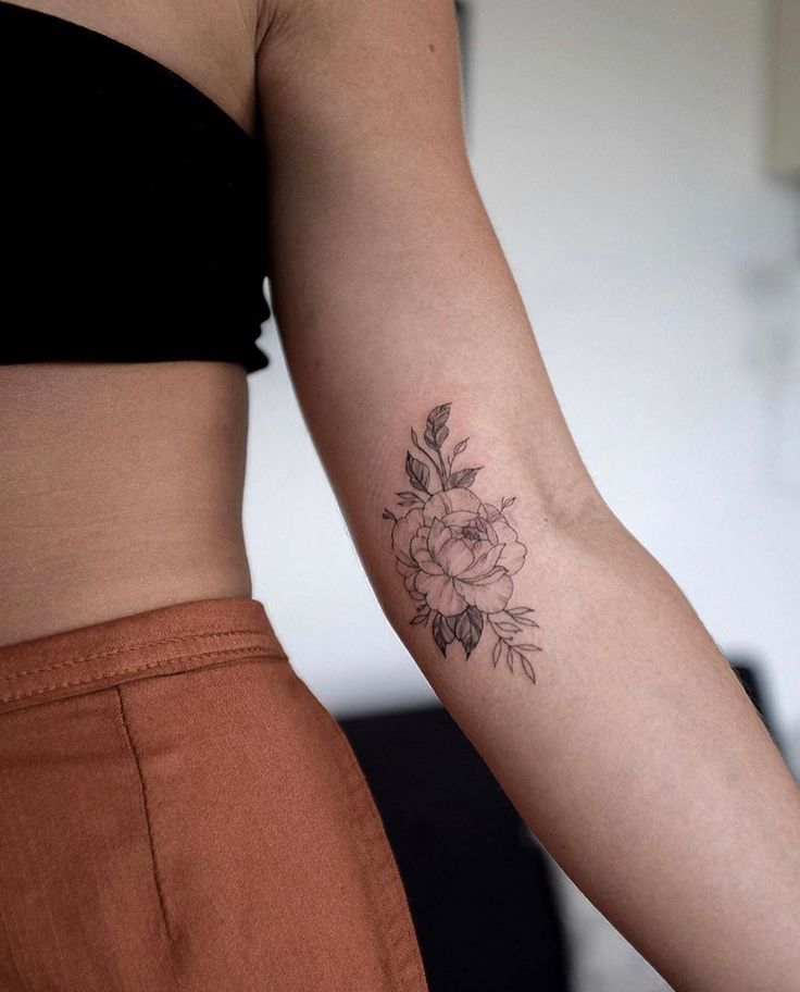 a woman's arm with a flower tattoo on the left side of her body