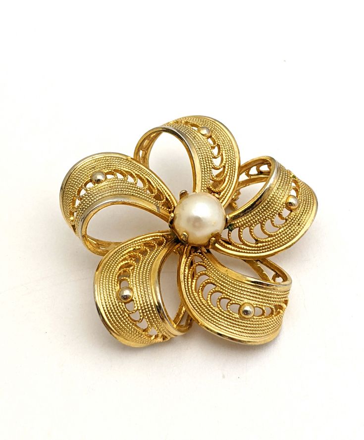 Vintage 60s small gold tone cut out filigree flower brooch with genuine freshwater pearl center. Ships USA, fast free shipping. Gift wrapping is available  Unsigned costume jewelry,  Pin measures 1.25" inches across No loss of gold tone Please see additional pics for more details and measurements Shipping includes tracking and insurance https://thejewelrycabinet.etsy.com www.instagram.com/thejewelrycabinet www.fb.com/thejewelrycabinet Elegant Gold Brooches For Spring, Gold Brooches For Spring Gift, Vintage Spring Wedding Jewelry, Gold Vintage Jewelry For Spring, Spring Gold Brooch Jewelry, Spring Gold Jewelry Brooch, Gold Brooch Jewelry For Spring, Spring Season Gold Brooch Jewelry, Spring Vintage Gold Jewelry