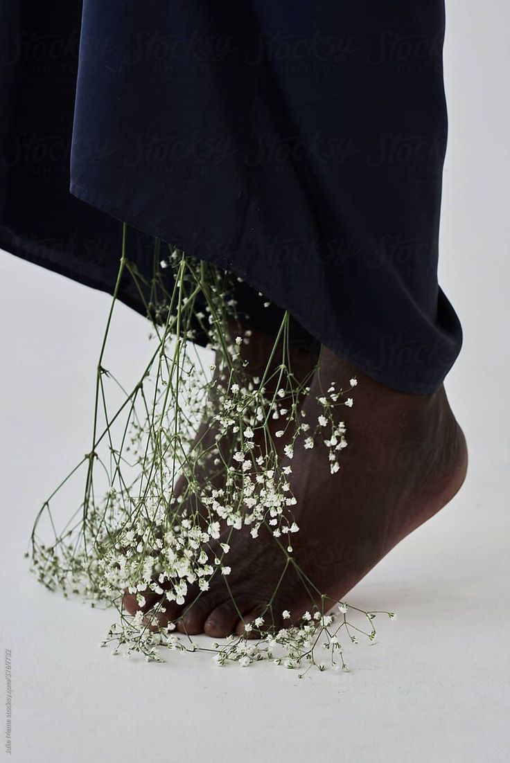 a person's feet with flowers on the ground by jovan for stocks & jones