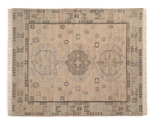 an antique rug with fringes and medallions on the center, in beige tones