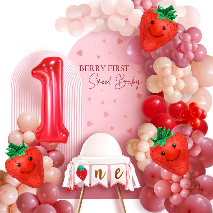 the first birthday cake is surrounded by balloons and strawberries, along with a number one sign