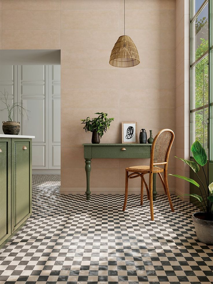 a room with a checkered floor and green table next to a plant in a pot