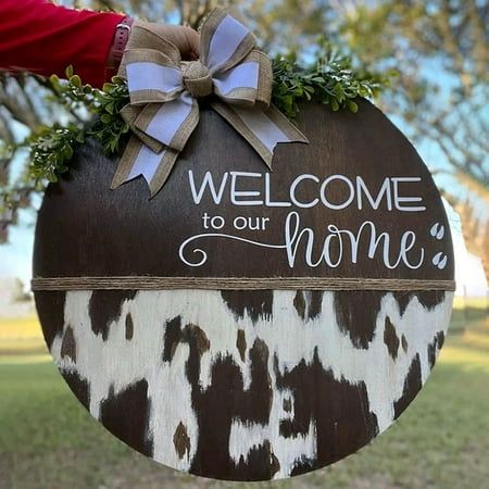 a sign that says welcome to our home with a bow on the front and back