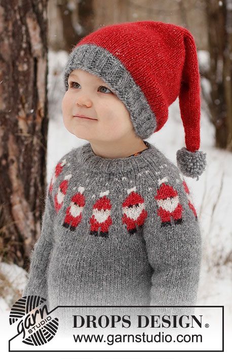 a little boy wearing a red and gray sweater with hearts on it in the snow