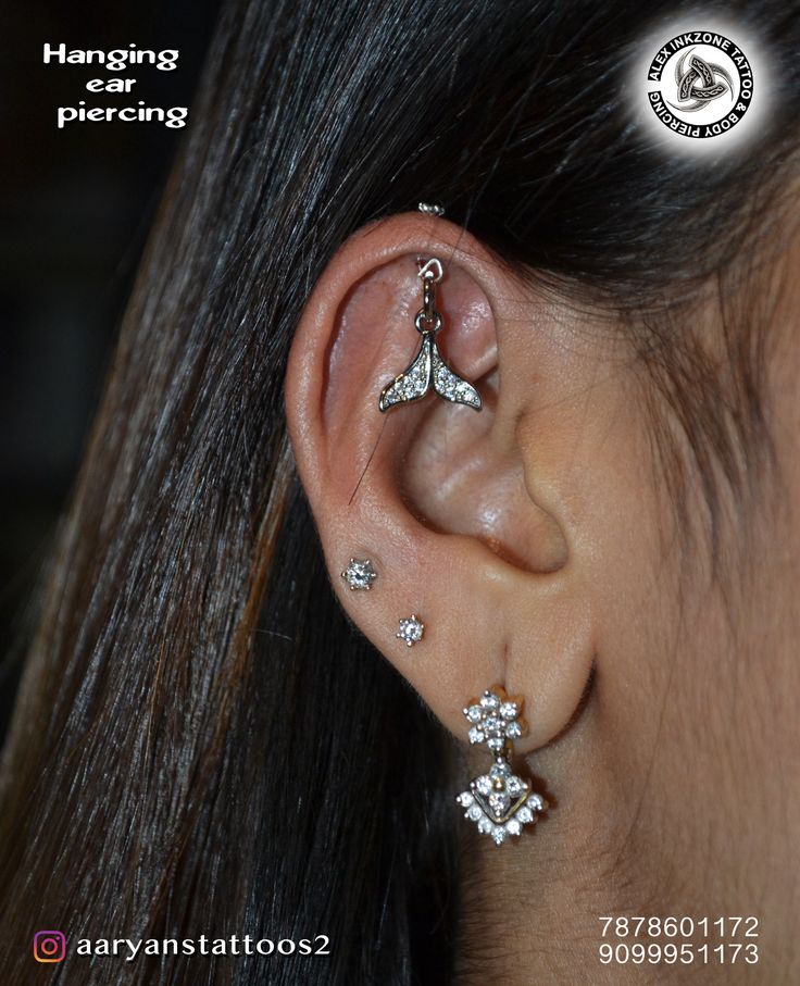 an ear piercing is shown with three small stars attached to the back of it's ear